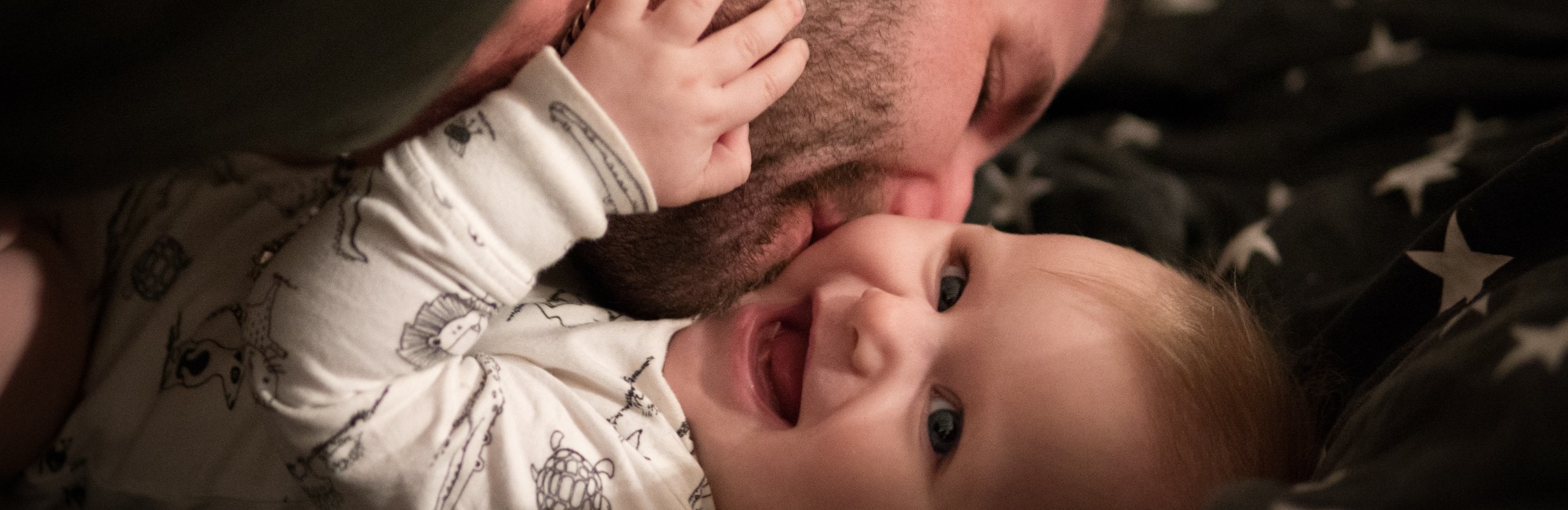 father kisses baby on cheek and baby laughs