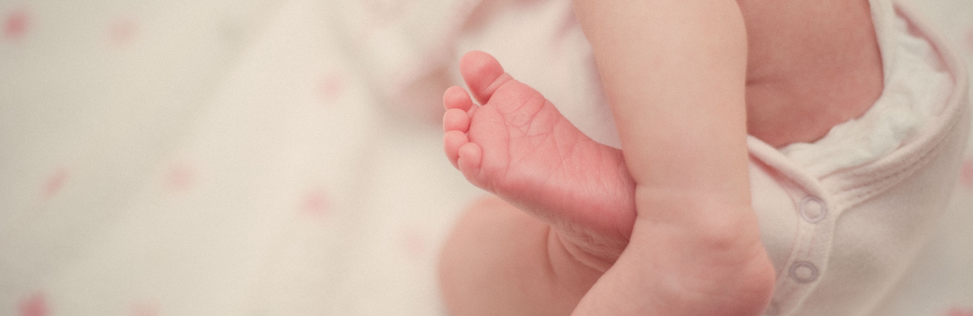 caucasian baby wearing white clothing's legs and feet