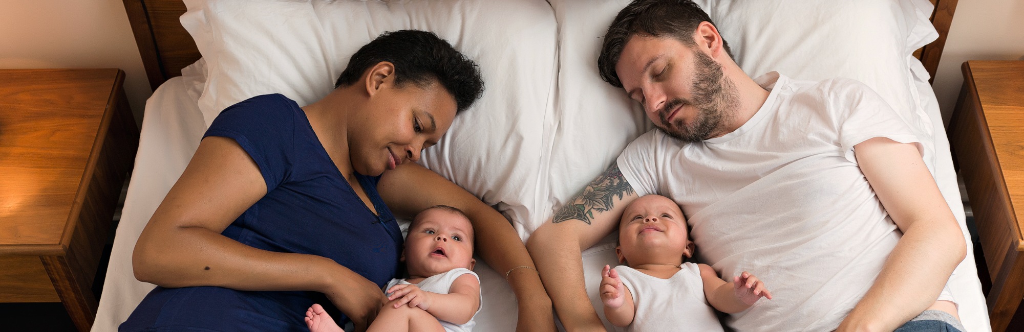 two babies and their parents safely bedsharing