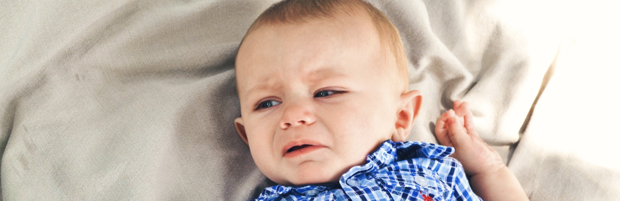 upset baby dialling up while laying on his back