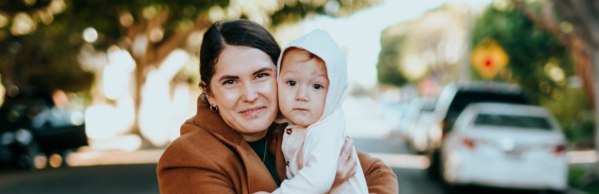 baby and mother outside walking on the street