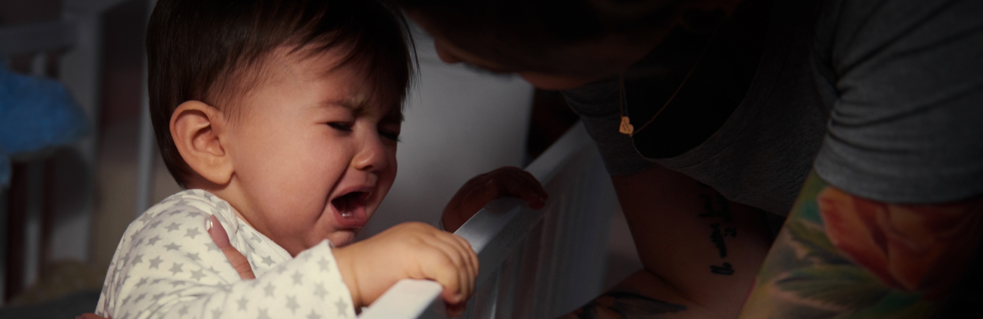 toddler crys by the edge of a cot