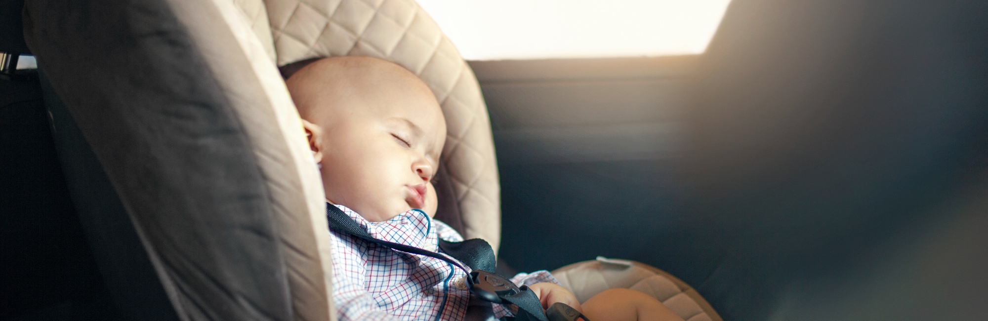 toddler asleep in car seat during the day
