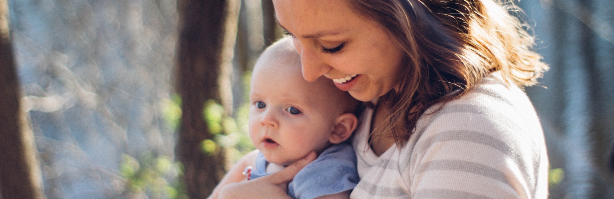 mum and baby playing outside near trees